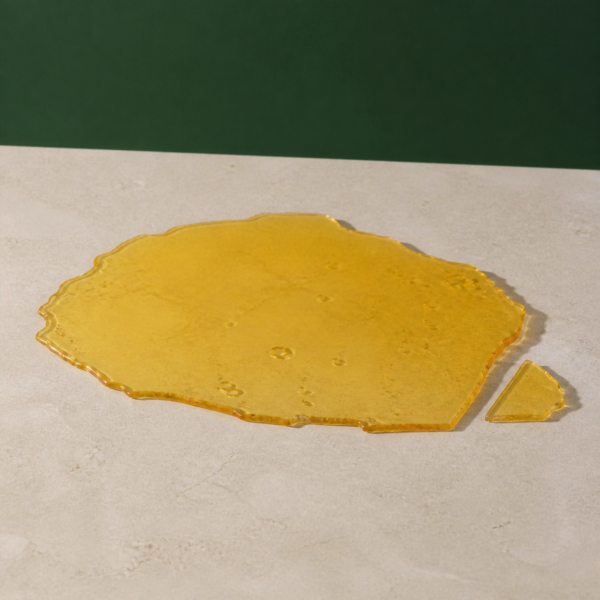 Good Giggles - Blue Dream House Shatter 1g on a pale stone surface