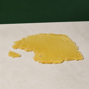Good Giggles - Jack Herer House Shatter 1g on a pale stone surface