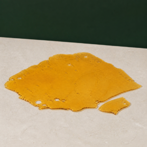 Good Giggles - Pink Pussy House Shatter 1g on a pale stone surface