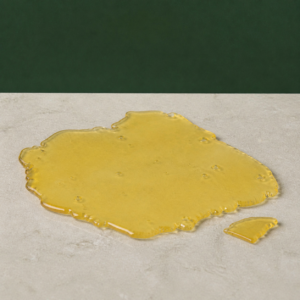 Good Giggles - Sour D House Shatter 1g on a pale stone surface
