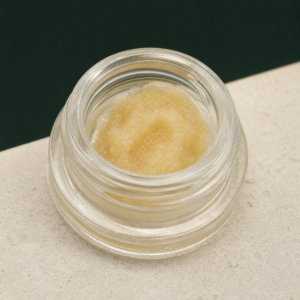 Rainbow Belt Live Resin open jar macro showing pale cream-golden concentrate texture