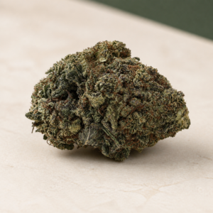 Tom Cat cannabis flower on a pale stone studio surface