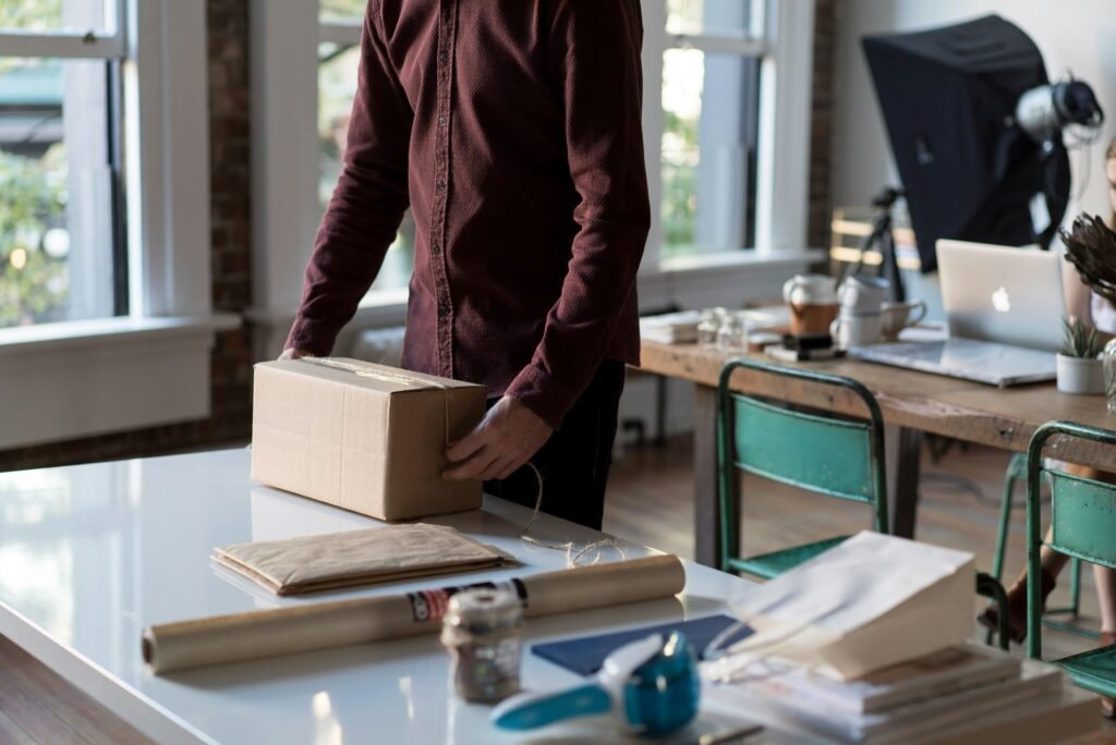 A plain cardboard parcel being prepared for delivery